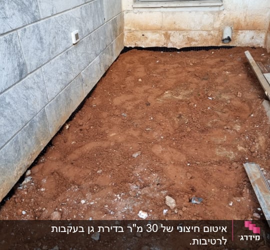 אדמה חשופה ליד קיר עם צינור ניקוז